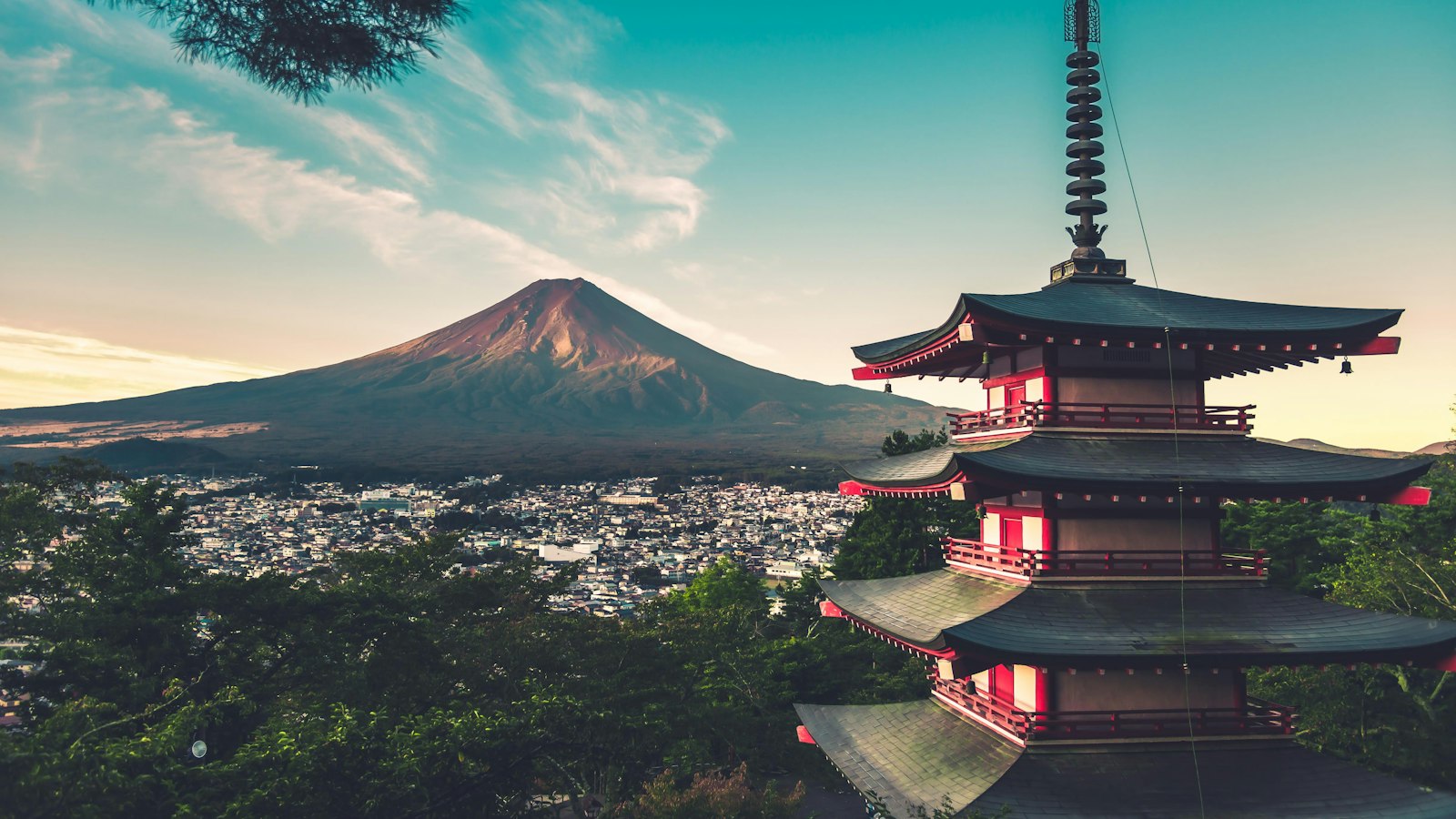 A red pagoda above the city with Mt Fuji in the distance