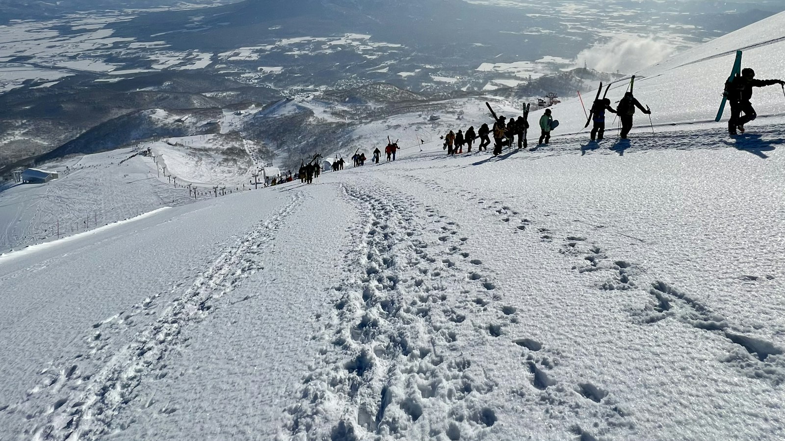 Skiers climbing a snow-covered slope in Hokkaido